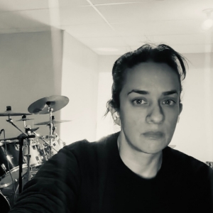 Woman in black and white with drum 