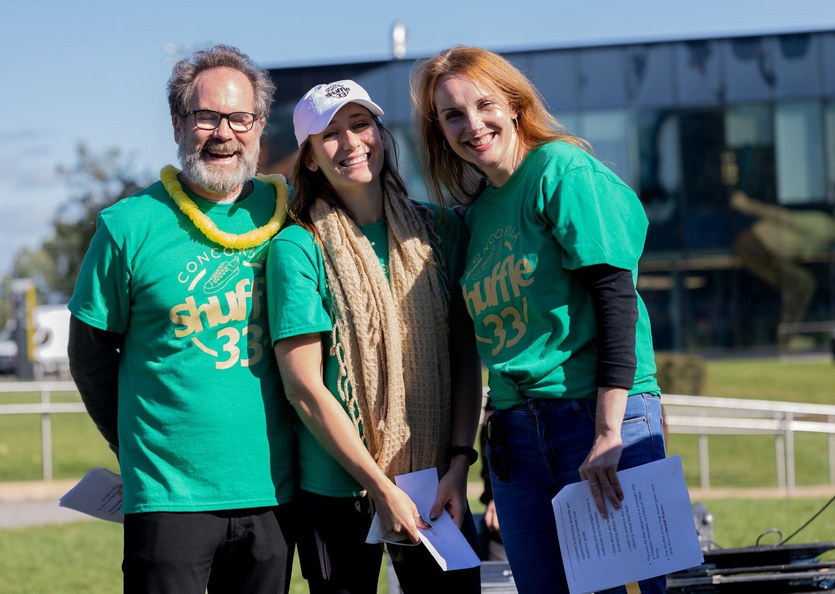 Trois personnes debout ensemble portant des T-shirts verts de la Marche de Concordia.