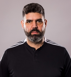 Karam Al-Hamdani a les cheveux foncés et une barbe, et porte un maillot de football noir