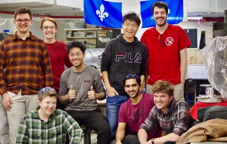 Huit étudiants se regroupent dans l'espace de travail du Club spatial de Concordia au sous-sol de l'édifice Henry F. Hall.