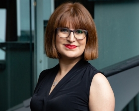 Un portrait de Zohreh Hajiakhondi-Meybodi portant des lunettes, une chemise noire et un collier