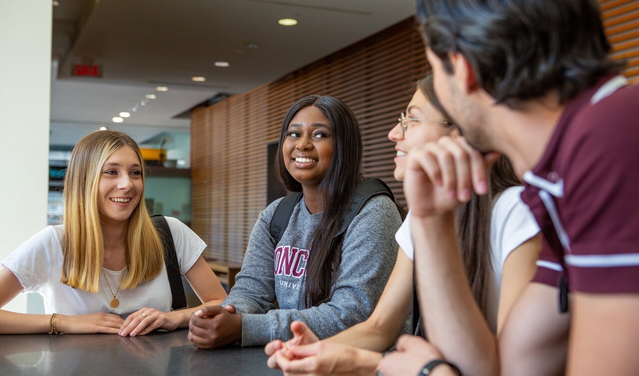 Image de quatre étudiants de l'Université Concordia discutant entre eux