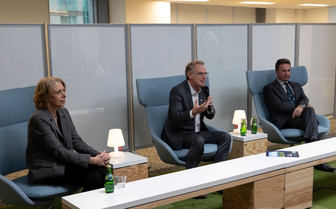  Trois professionnels assis sur des chaises bleues semblent participer à une séance de questions-réponses.