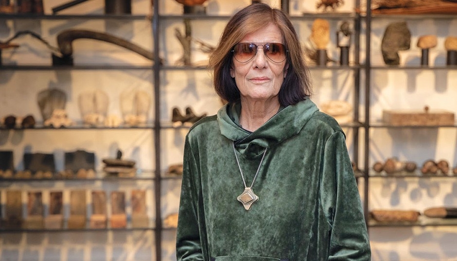 Sylvia Safdie Sylvia se tient devant ses œuvres d'art alignées sur des étagères.
