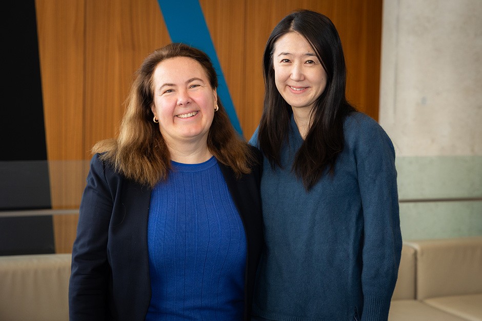 Deux femmes se tiennent côte à côte et sourient.