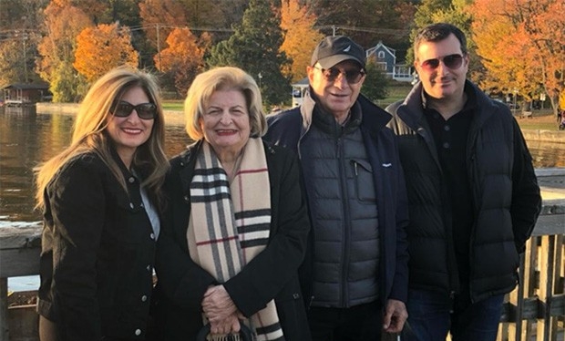 Quatre personnes se tiennent sur un pont, au milieu des couleurs de l'automne.
