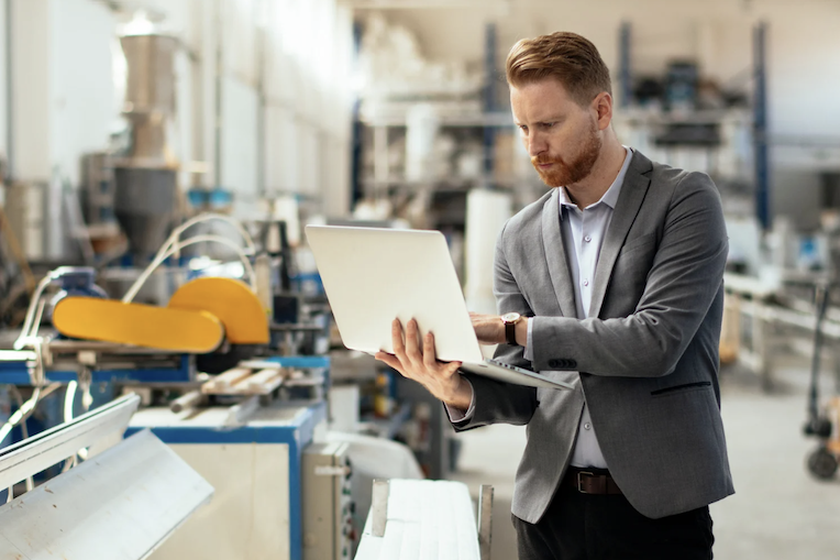Un homme utilise un ordinateur portable dans une usine
