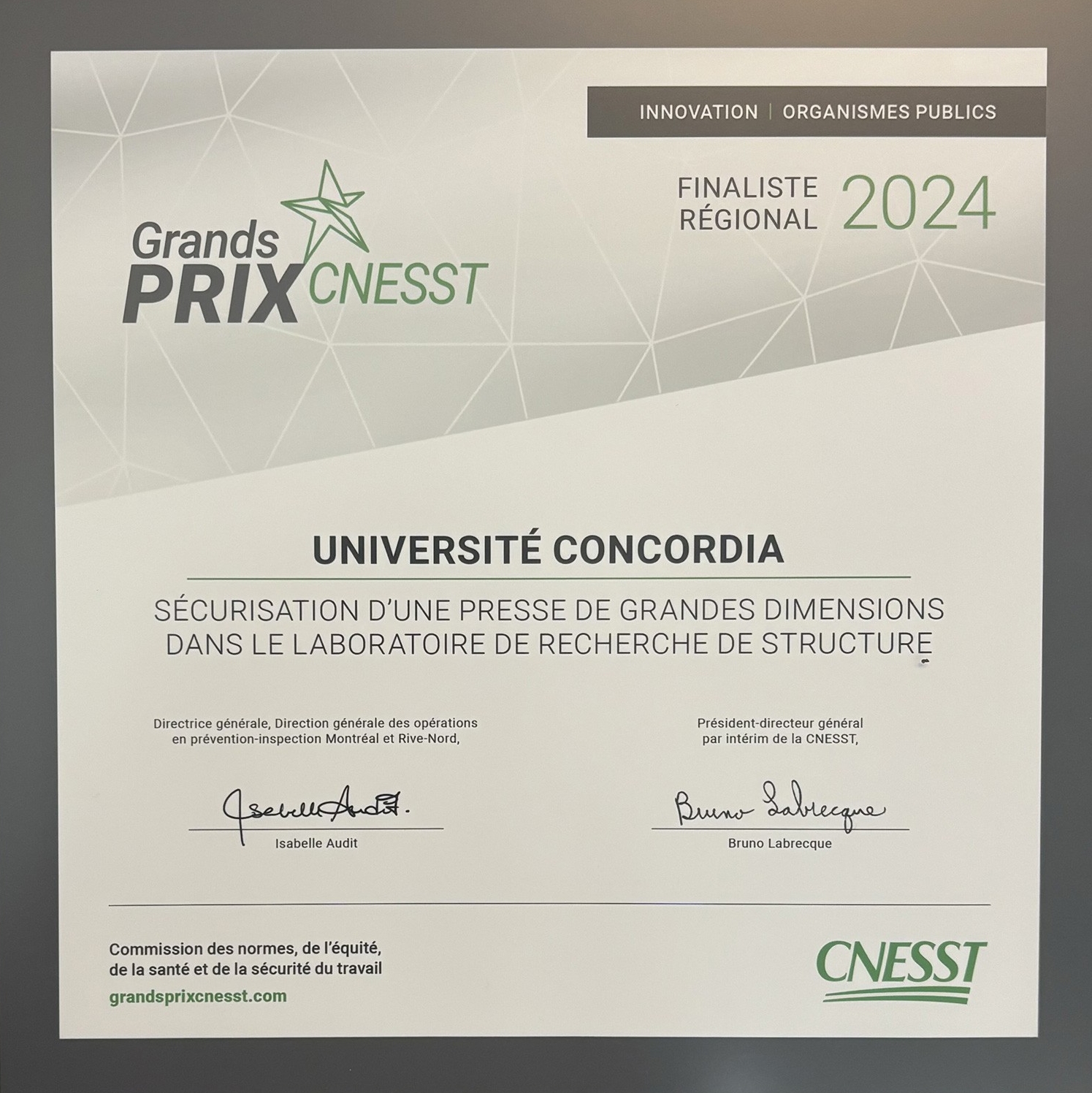 Un certificat encadré nommant l'Université Concordia finaliste des Grands Prix 2024 de la CNESST pour la sécurisation d'un cadre de test à haute capacité dans un laboratoire de recherche.
