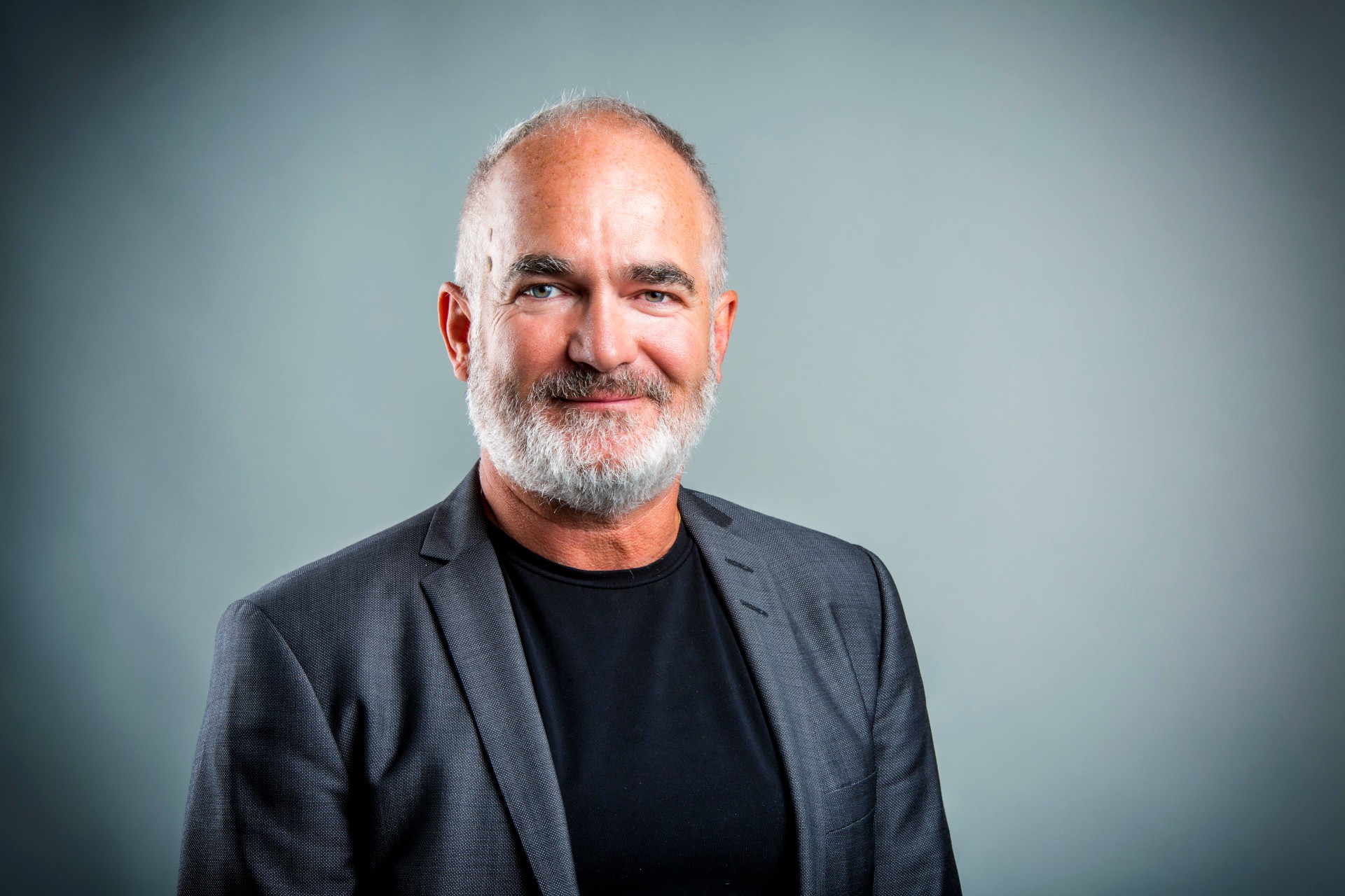 Portrait of a man with a beard wearing a blazer.