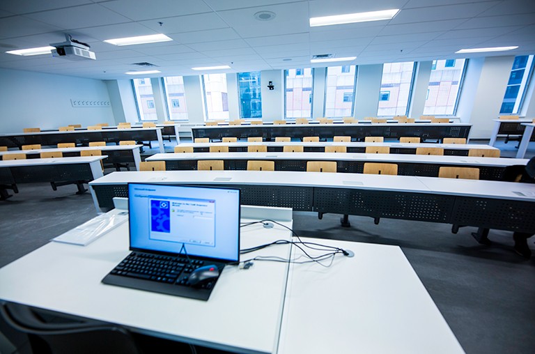 Picture of an interior corridor with a black and glass wall leading to a bathroom.