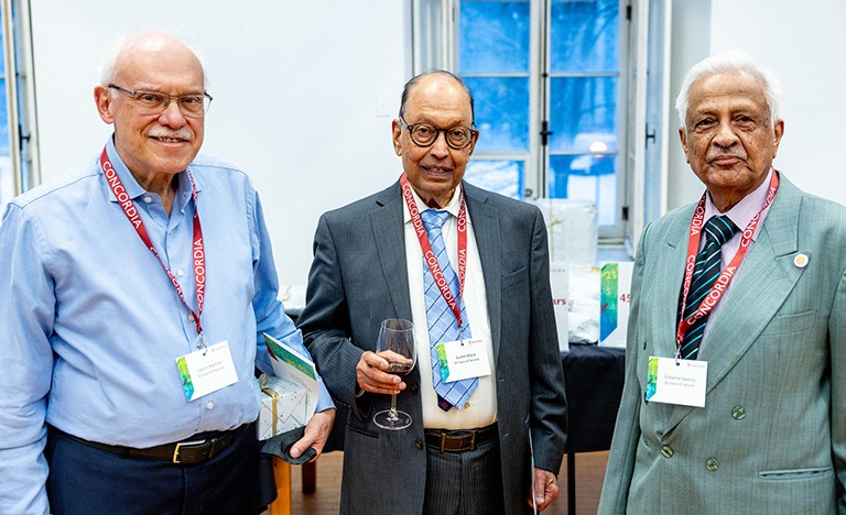 Trois hommes d'un certain âge, en costume-cravate, souriant à l'appareil photo.