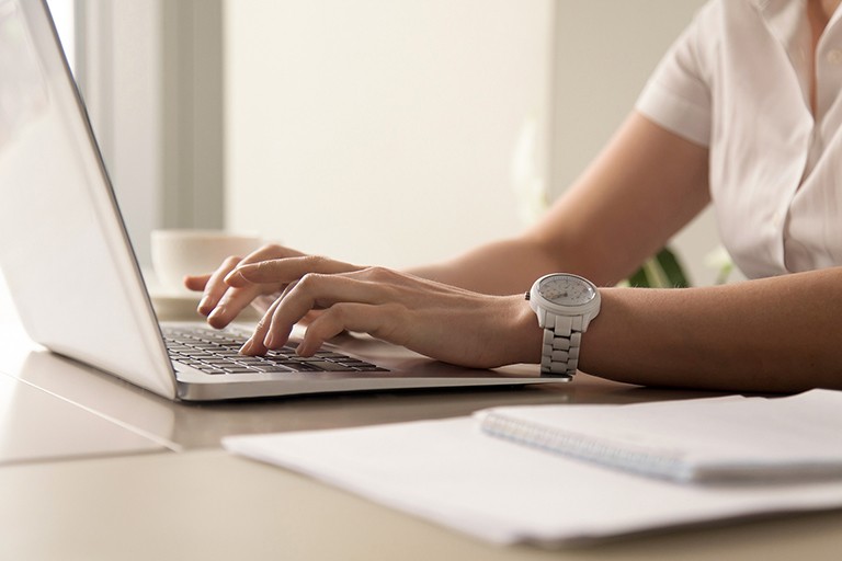 Photo of someone's hands using a laptop